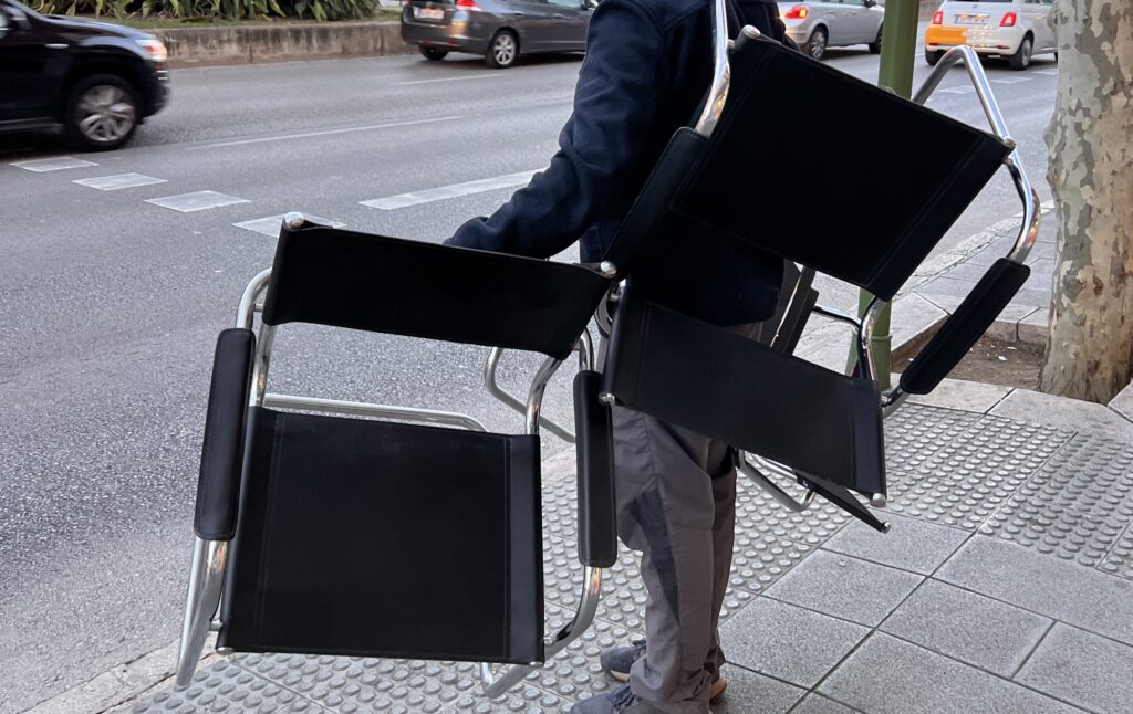 Hombre cargando sillas vintage